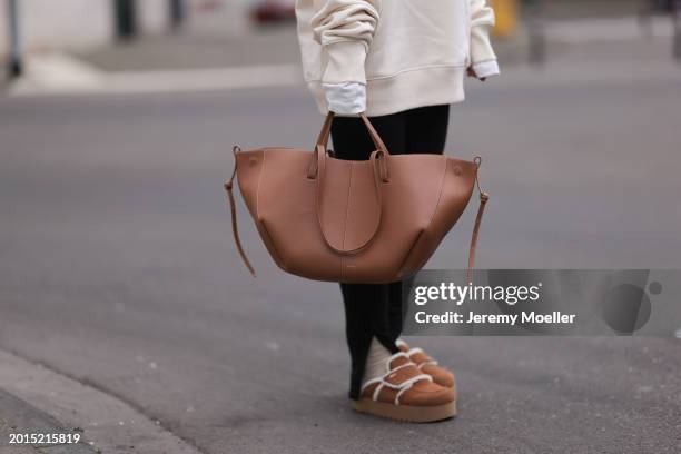 Elise Rozay seen wearing Hernameis creamy white logo print pattern oversized sweater, Zara black split leggings pants, Hernameis beige wool knit...