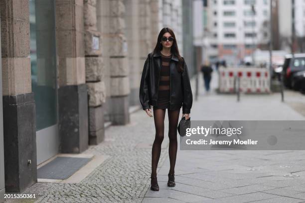 Celine Bethmann seen wearing Chanel vintage black oval sunglasses, Dior gold earrings, Norma Kamali brown / transparent striped short dress, Wolford...