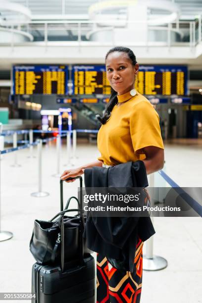 elegant businesswoman waiting at airport departure hall - bolsa preta imagens e fotografias de stock