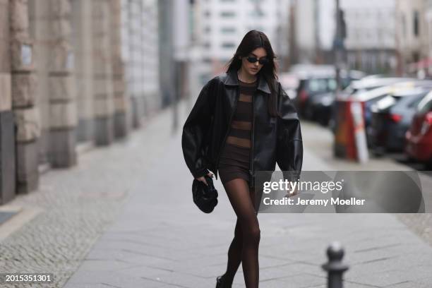 Celine Bethmann seen wearing Chanel vintage black oval sunglasses, Dior gold earrings, Norma Kamali brown / transparent striped short dress, Wolford...