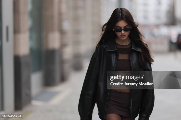 Celine Bethmann seen wearing Chanel vintage black oval sunglasses, Dior gold earrings, Norma Kamali brown / transparent striped short dress, Wolford...