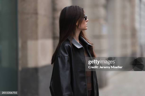 Celine Bethmann seen wearing Chanel vintage black oval sunglasses, Dior gold earrings, Norma Kamali brown / transparent striped short dress and a...