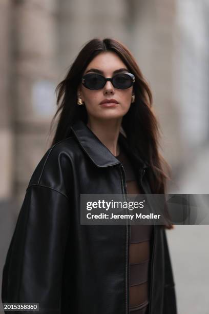 Celine Bethmann seen wearing Chanel vintage black oval sunglasses, Dior gold earrings, Norma Kamali brown / transparent striped short dress and a...