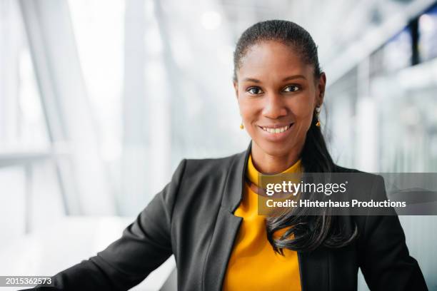 portrait of elegant businesswoman sitting in airport lounge vip area - einzelne frau über 40 stock-fotos und bilder