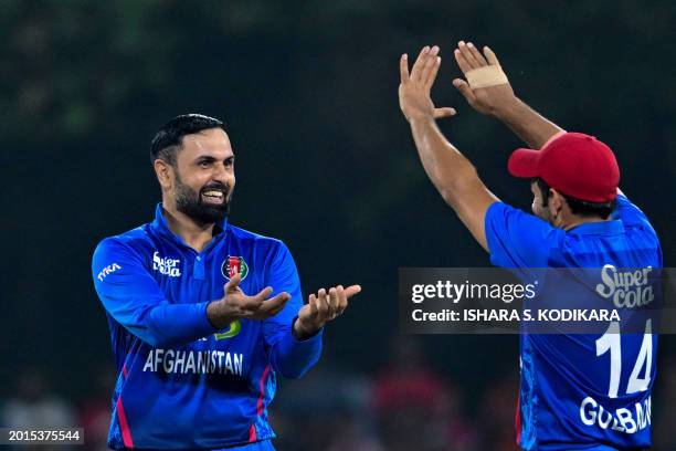 Afghanistan's Mohammad Nabi celebrates with his teammate after taking the wicket of Sri Lanka's Wanindu Hasaranga during the second Twenty20...