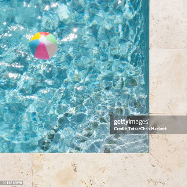 beach ball floating in swimming pool - beach ball pool stock pictures, royalty-free photos & images