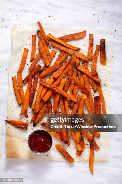 overhead view of sweet potato fries and small bowl of ketchup - zoete aardappel stockfoto's en -beelden