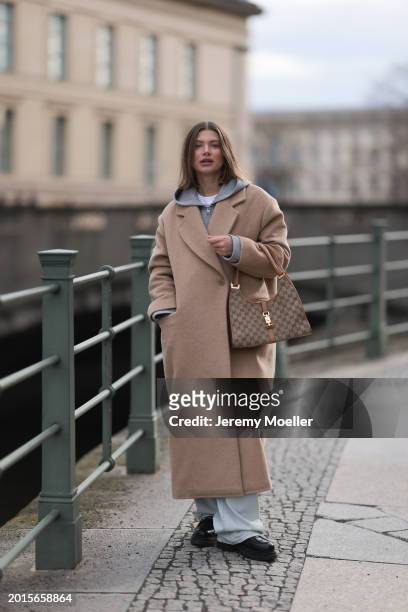 Sophia Geiss is seen wearing Arket light grey cotton hooded zip jacket, LeGer light blue wide leg denim / baggy jeans, LeGer beige oversized long...