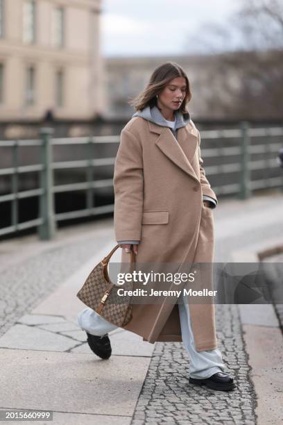 Sophia Geiss is seen wearing Arket light grey cotton hooded zip jacket, LeGer light blue wide leg denim / baggy jeans, LeGer beige oversized long...