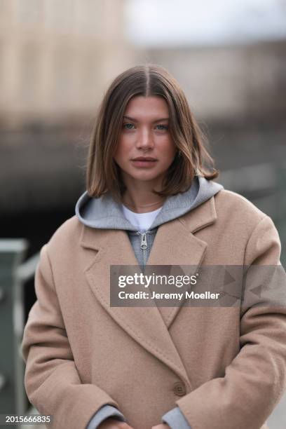 Sophia Geiss is seen wearing Arket light grey cotton hooded zip jacket, LeGer beige oversized long wool coat, on February 16, 2024 in Berlin, Germany.