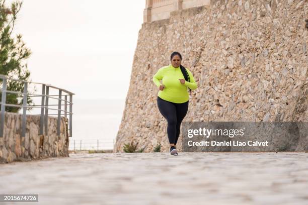overweight woman running to lose weight - running woman woman stock pictures, royalty-free photos & images