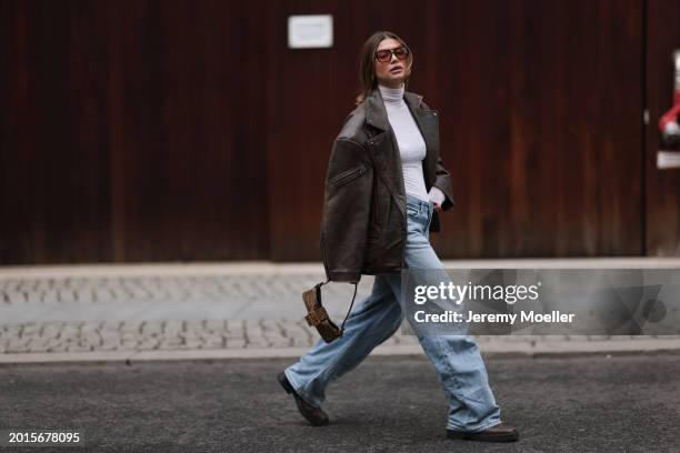 Sophia Geiss is seen wearing Vehla Eyewear brown sunglasses, Intimissimi white sheer high neck cashmere top, Weekday blue denim oversized baggy...
