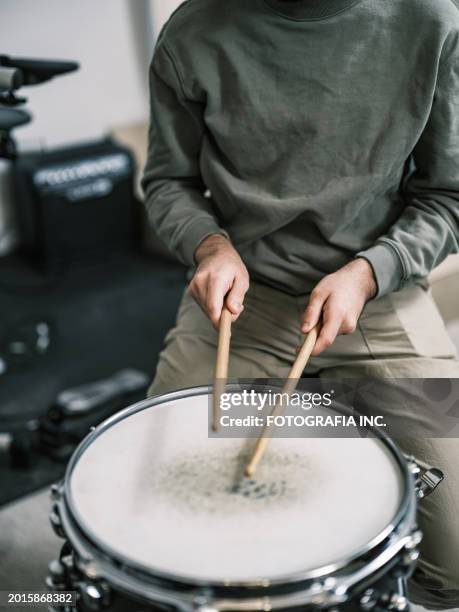 mains d’un étudiant en musique masculin au studio de musique de batterie - batteur photos et images de collection
