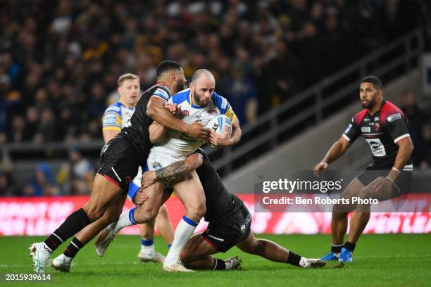 Matt Frawley of Leeds Rhinos is tackled by Kallum Watkins of Salford Red Devils and Nene Macdonald of Salford Red Devils during the Betfred Super...