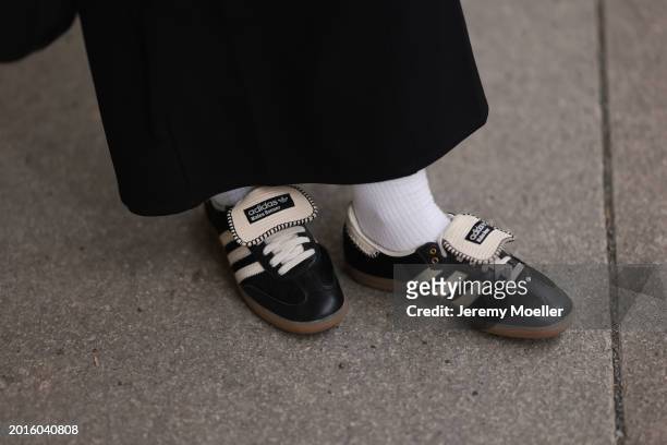 Sophia Geiss is seen wearing Edited black belted long skirt, white cotton socks and Adidas x Wales Bonner black / white leather sneakers, on February...