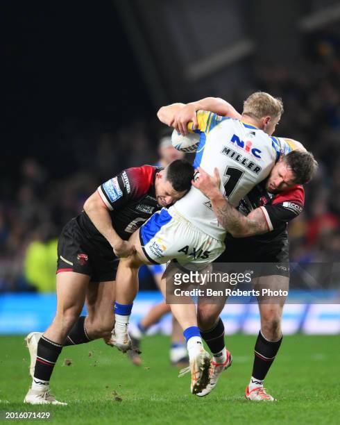 Lachlan Miller of Leeds Rhinos is tackled by Cade Cust of Salford Red Devils and Ben Hellewell of Salford Red Devils during the Betfred Super League...