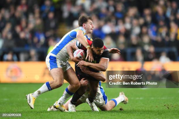 Nene Macdonald of Salford Red Devils is tackled by Paul Momirovski of Leeds Rhinos during the Betfred Super League match between Leeds Rhinos and...