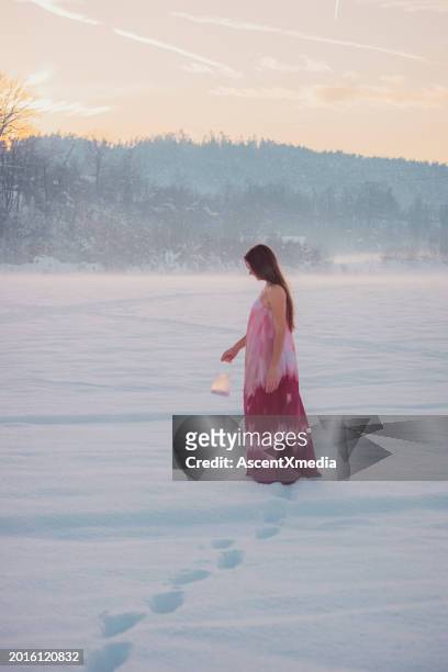young woman explores winter landscape with lantern - spaghetti straps stock pictures, royalty-free photos & images