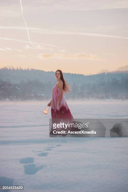 young woman explores winter landscape with lantern - spaghetti straps stock pictures, royalty-free photos & images