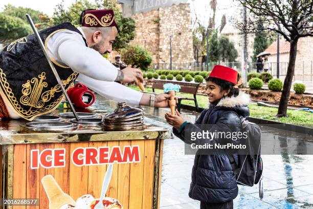 Girl catches a traditional Turkish ice cream offered with traditional vendor tricks in Antalya, a tourist resort in southern region of the Republic...