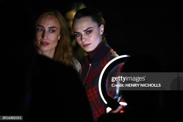 British models Elizabeth Jagger and Cara Delevingne pose for a photo as they arrive to attend the catwalk presentation for British fashion house...