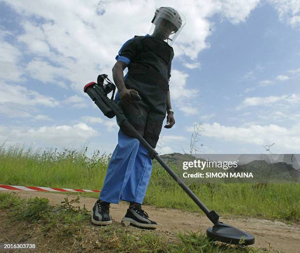 Deminer attached with a South African deming team, Mechem, uses a metal detector 09 August 2005 to check for deadly landmines in the road linking the...