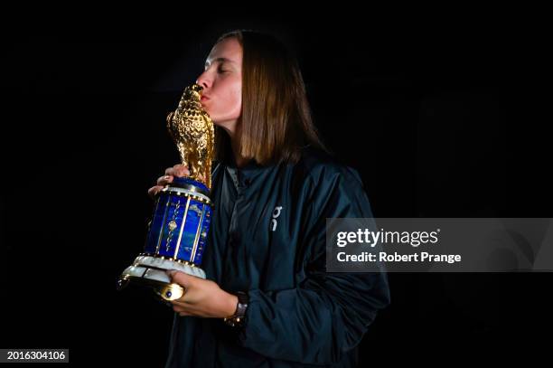 Iga Swiatek of Poland poses with the champions trophy after defeating Elena Rybakina of Kazakhstan in the singles final on Day 7 of the Qatar...