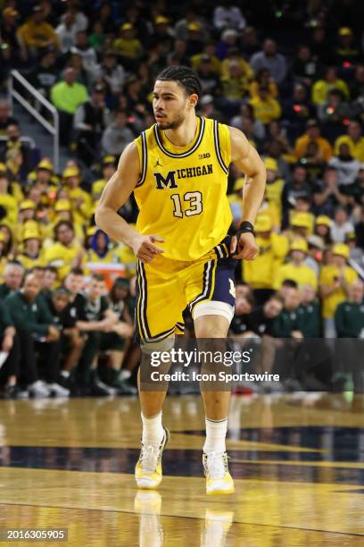 Michigan Wolverines forward Olivier Nkamhoua runs up the court during a regular season Big Ten Conference college basketball game between the...