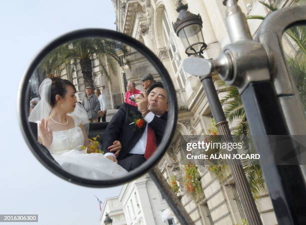 One of the 40 Chinese married couples coming from Tianjin , leaves in an ancient car Tours' townhall, after the confirmation of their wedding by...