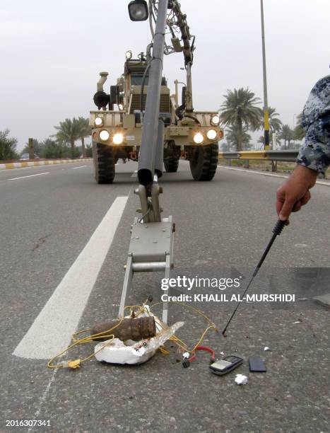 An Iraqi sapper points to a cell phone used to trigger the road side bomb protected in styrofoam after being located and disarmed by the Iraqi army...