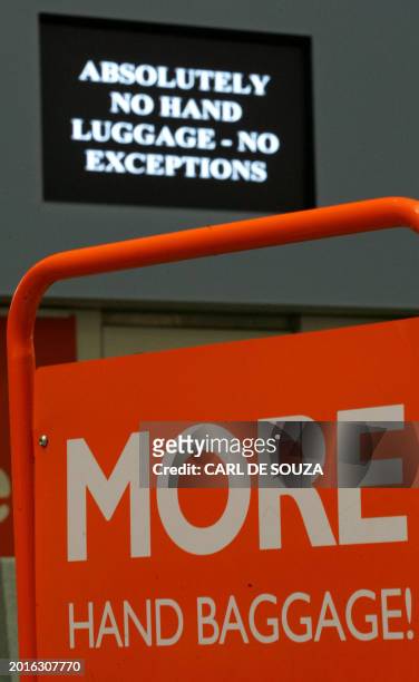 An Easyjet airlines sign promoting their increased baggage allowance is seen in front of security warnings on screen that hand baggage allowance has...