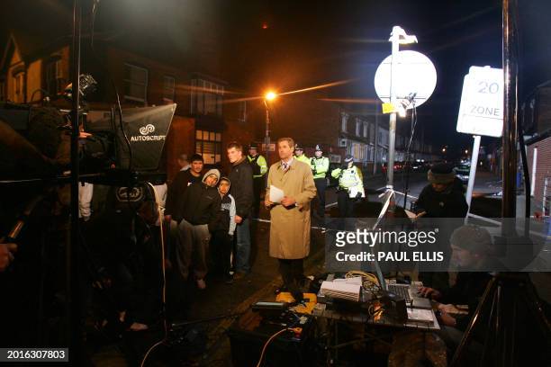 British television crew presents a news bulletin from the end of Jackson Street in Birmingham, central England, 31 January 2007 after a raid in the...