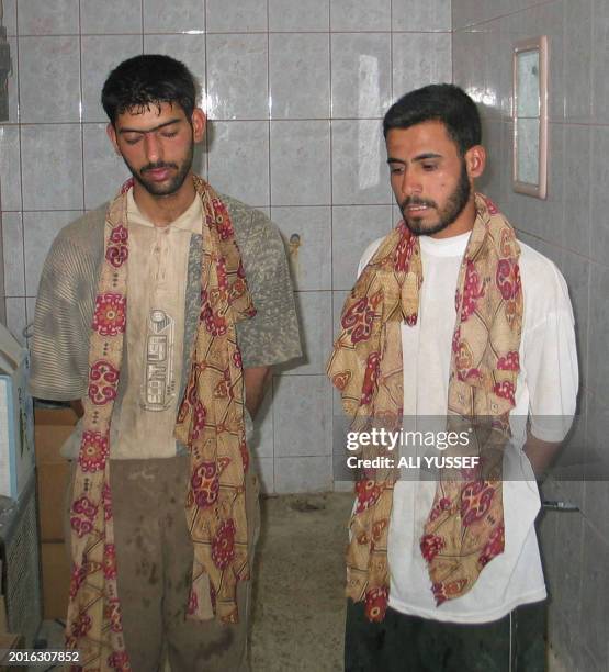 An image made available by the Iraqi police 29 May 2005, shows two alleged suspects standing with cloth around their necks, used to blind fold them,...