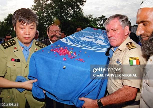 United Nations military official Lieutenant Colonel Jang from China and an unidentified UN official from Ireland lead other officials carry the...