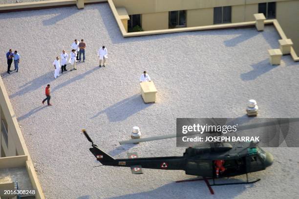 Lebanese doctors and relief workers watch a helicopter landing on the roof of the Hotel Dieu De France hospital during a Lebanese army anti-terrorism...