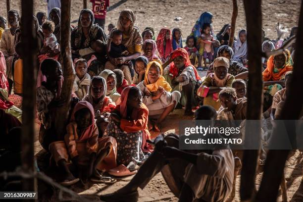 Sudanese refugees and ethnic South Sudanese families who have fled from the war in Sudan gather after crossing the border while waiting to be...