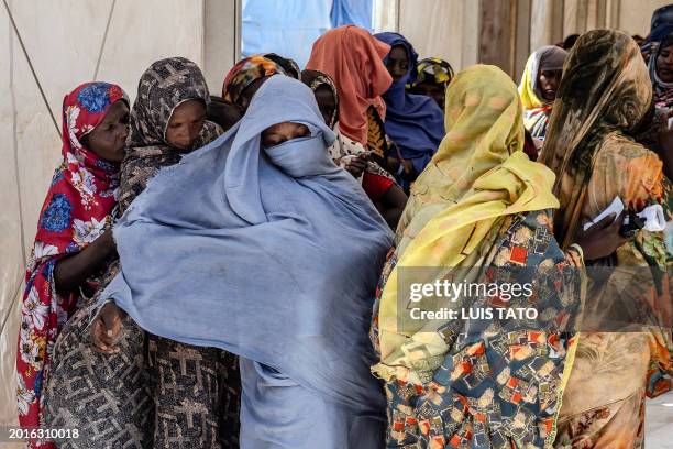 Sudanese refugees who have fled from the war in Sudan line up during a cash assistance programme at a Transit Centre for refugees in Renk, on...