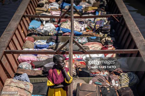 South Sudanese girl stands on a boat loaded with belongings from families who have fled the war in Sudan at the shores of the White Nile River in the...