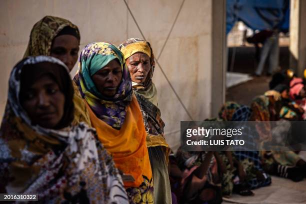 Sudanese refugees who have fled from the war in Sudan line up during a cash assistance programme at a Transit Centre for refugees in Renk, on...