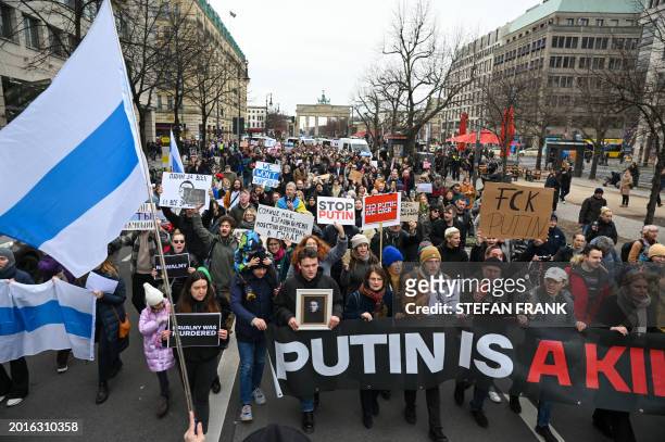 People hold placards in a rally on February 18 in front of the Russian embassy in Berlin, following the death of Alexei Navalny. People gathered to...