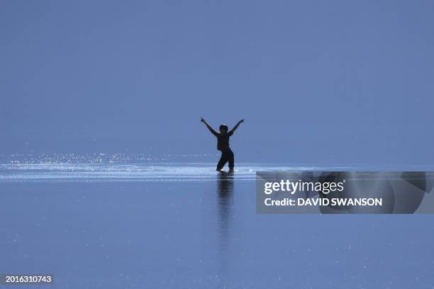 Tourist enjoys the rare opportunity to play knee deep in salty water as they visit Badwater Basin, the normally driest place in the US, in Death...