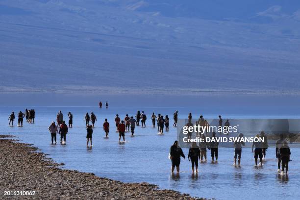 Tourists enjoy the rare opportunity to walk knee deep in briney water as they visit Badwater Basin, the normally driest place in the US, in Death...