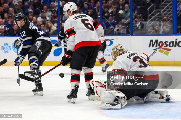 Alex Barre-Boulet of the Tampa Bay Lightning tries to tip the puck past Anton Forsberg and Jakob Chychrun of the Ottawa Senators during the second...