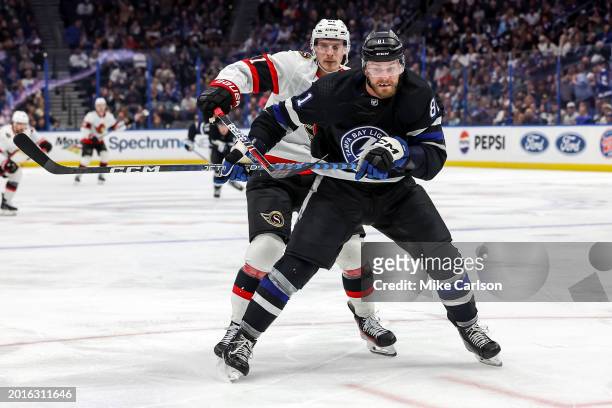 Erik Cernak of the Tampa Bay Lightning battles Dominik Kubalik of the Ottawa Senators for a loose puck during the third period of the game at the...