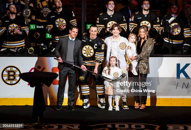 Brad Marchand of the Boston Bruins and his family celebrate his 1,000th NHL game during a ceremony with General Manager Don Sweeney before a game...