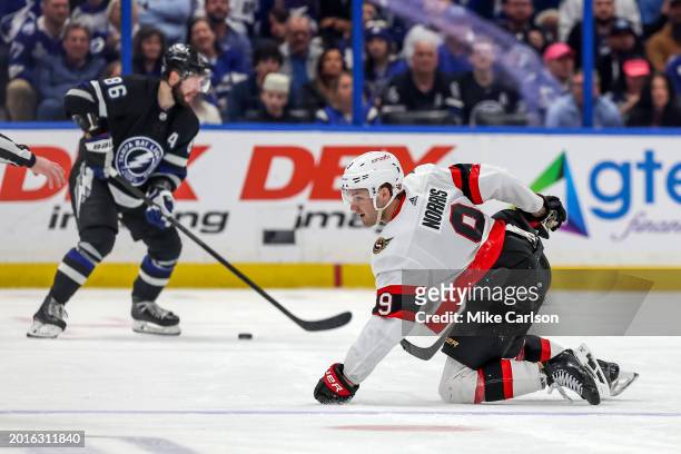Josh Norris of the Ottawa Senators slides back to the bench after losing his skate blade as Nikita Kucherov of the Tampa Bay Lightning controls the...