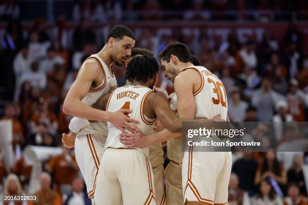 Texas players huddle up during a timeout of the Big 12 college basketball game between Texas Longhorns and Kansas State Wildcats on February 19 at...