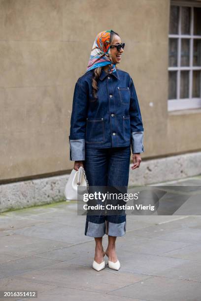 Guest wears head scarf, cuffed denim jacket, jeans, white Alexander Wang bag, heels outside Huishan Zhang during London Fashion Week February 2024 on...
