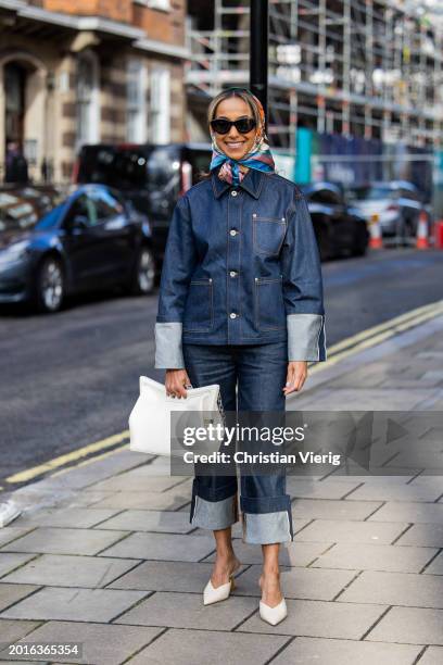 Guest wears head scarf, cuffed denim jacket, jeans, white Alexander Wang bag, white heels outside Bora Aksu during London Fashion Week February 2024...