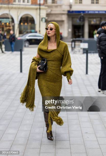 Betty Bachz wears hooded knit dress, brown boots, black bag outside Mark Fast during London Fashion Week February 2024 on February 16, 2024 in...